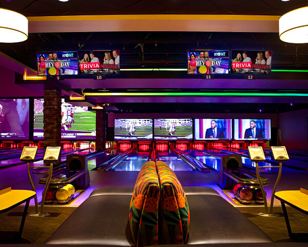 Bowling lanes with big screens and colorful lights